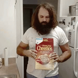 man wearing white shirt holding a bag of cheerios cereal