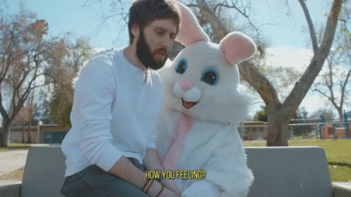 a man sitting down with a huge stuffed rabbit