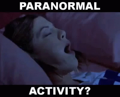 there is a person lying in bed with the text paranormal activity on it