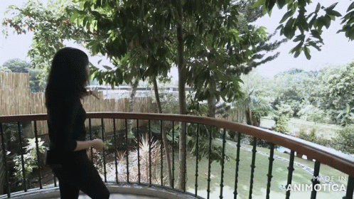 a girl walking away from her home on her balcony