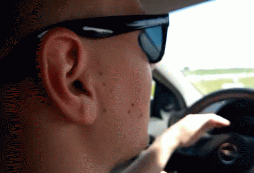 a man driving with a blue mask on and head turned sideways