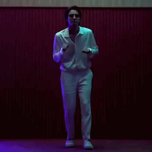 a man with sunglasses is walking on a stage