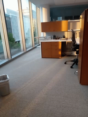 an empty office with lots of furniture and large windows