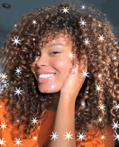 a woman smiling and covering her face with stars