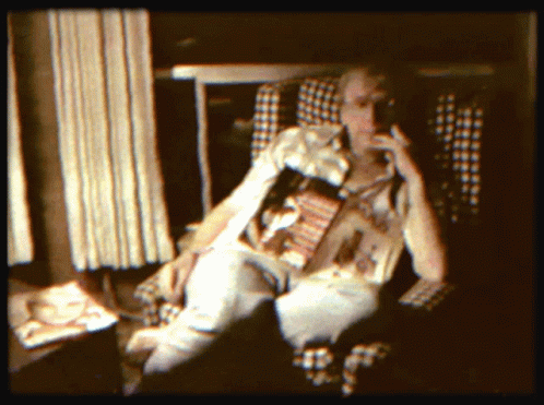a person in striped shirt holding up a magazine