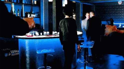a man standing at the bar in the dark
