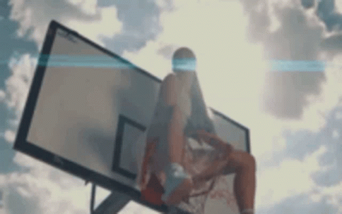 a man is sitting on the basketball hoop