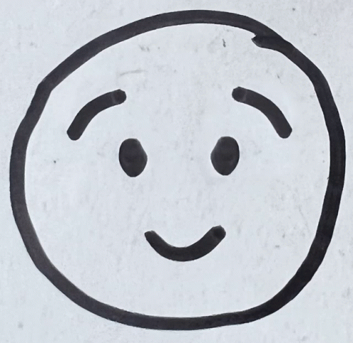 a black smiley face drawn on a white surface