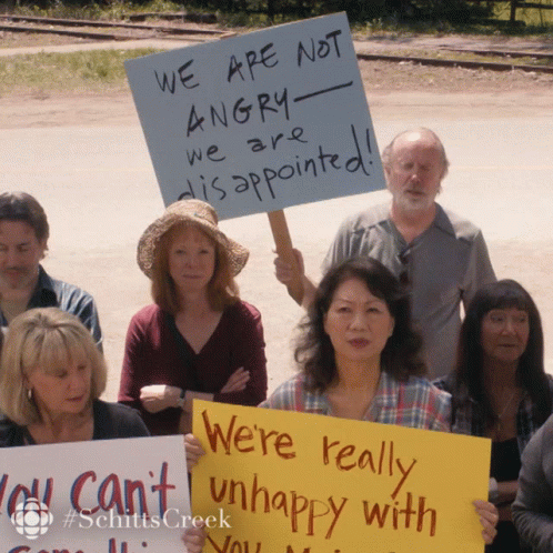 a group of people standing next to each other holding up signs