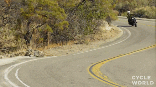 a motorcycle rider turning a curve in the road