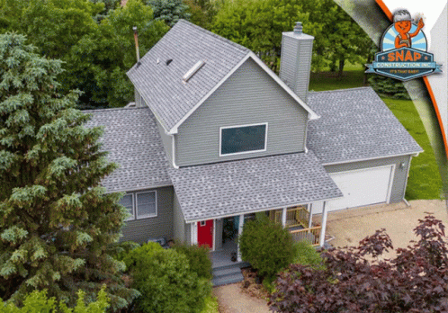 a large gray house with a roof made from shingles