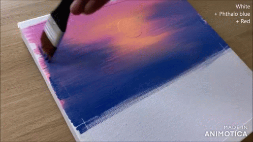 a person painting on some paper in purple and blue
