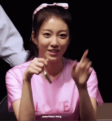 an asian woman giving the peace sign with her hands