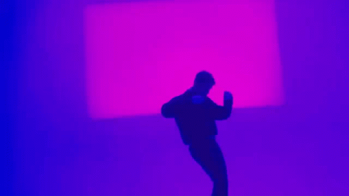 a man taking a picture in front of purple light