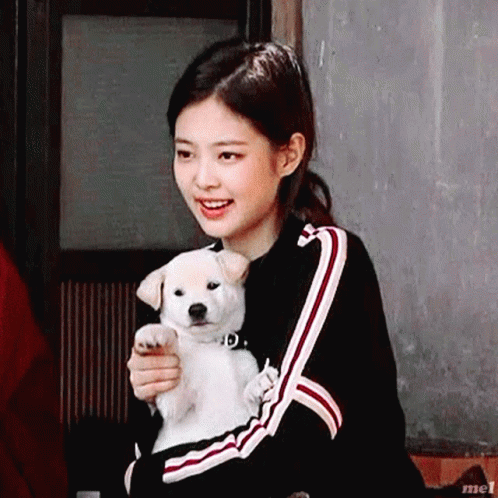a woman holding a dog smiling at the camera