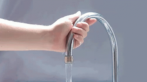 an image of hand holding water pouring from faucet