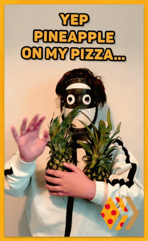 a man wearing a blue mask holding some pineapples