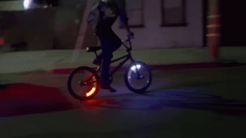 a person on a lighted bike and with a camera