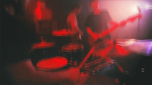 blurry image of electric guitar and drums in bedroom