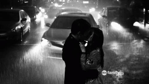 a black and white po of people kissing in the rain