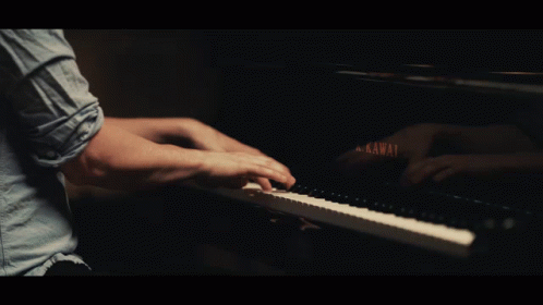 a man sitting at a piano playing with his hands