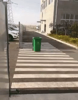 there is a green box sitting at the end of a street