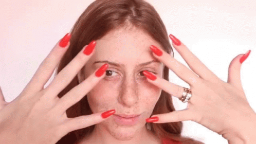 a person with blue nail polish holding their hands up to their face