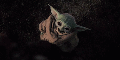 a baby yoda in the dark with his head sticking out