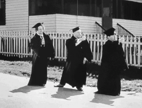 three people with a hat and gown on a road
