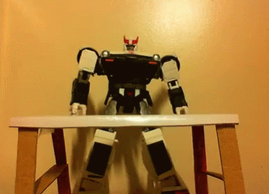 a black and gray robot sitting on a white table