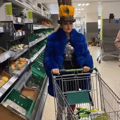 a woman wearing a weird costume hes a shopping cart
