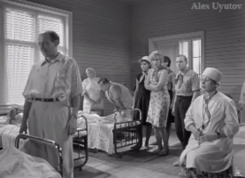 a group of doctors stand in front of beds with young women