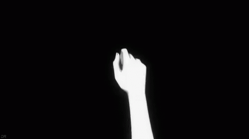 a person's arm reaching up into the dark