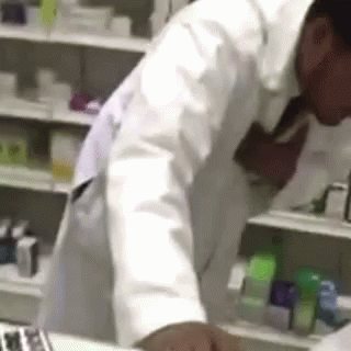 a pharmher in his lab coat picking some medicine