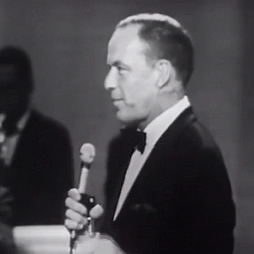 a man holding a microphone speaking into a microphone