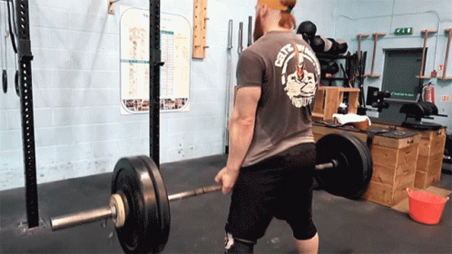 a man in a gym lifting a barbell