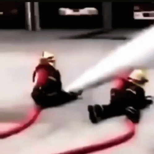 two men on the floor playing with a hose