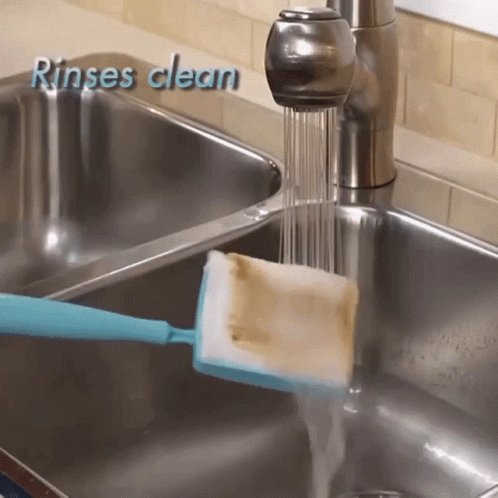 a yellow scrubber is being used to clean the sink