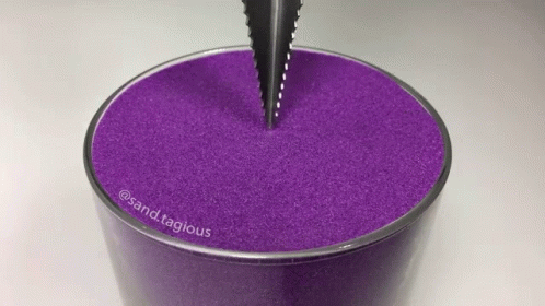 purple cup sitting in the middle of a table with a pen sticking out of it