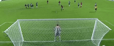 a soccer game is being played inside an artificial soccer field
