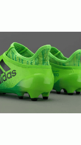 green soccer shoes with black and white logo on the soles