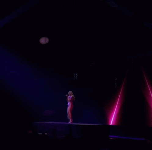 the woman is standing alone on stage and singing