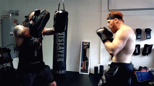 a man in a room with a punching bag and a man with blue hair