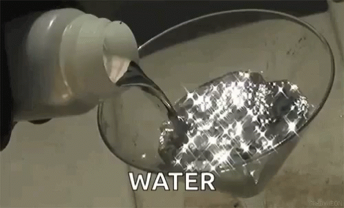 a person pours water into a glass that is in a sink