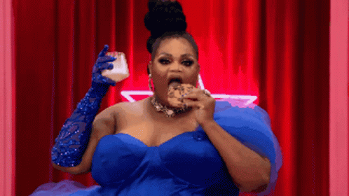a black woman in a red dress holds a donut to her mouth