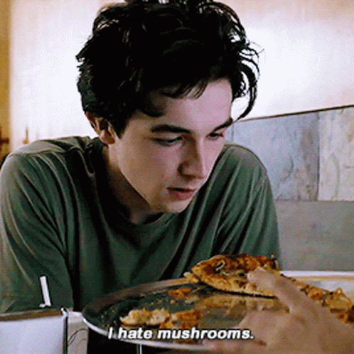 a young man looking at pizza and the caption hate mushrooms