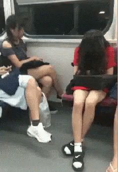 several people sit and stand near each other on a public transit train