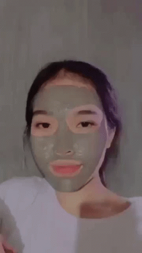 woman using face mask to cleanse and correct her skin
