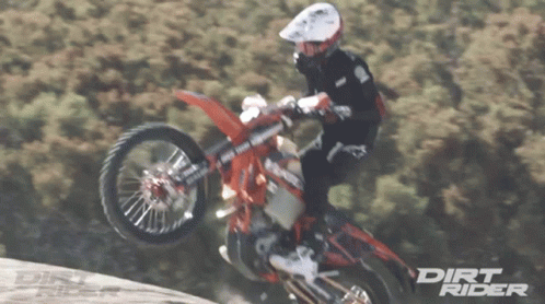 there is a man that is jumping over a hill on his motor bike