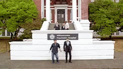 two men are standing in front of a statue